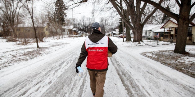 FLINT, MI - JANUARY 21: American Red Cross volunteer John Lohrstorfer walks down Maryland St. on Flint's north side to deliver water and filters to homes on January 21, 2016 in Flint, Michigan. The Red Cross is supporting state and county efforts to bring water to every household in the city. (Photo by Sarah Rice/Getty Images)