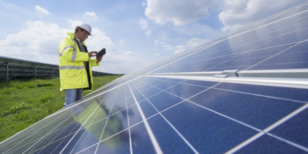 Mixed race man with digital tablet checking solar panels