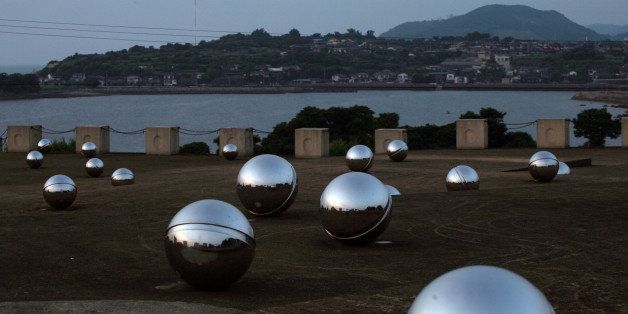 A memorial for those who died or were sickened by mercury poisoning rests on a hill overlooking the town of Minamata, Japan and the Minamata Bay on June 8, 2007. (AP Photo/David Guttenfelder)