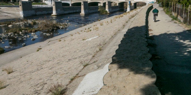 A cyclist rides along recently installed temporary flood control walls along the L.A. River in Los Angeles Friday, Feb. 12, 2016. The US Army Corps of Engineers installed about three miles of temporary barriers along the river through Griffith Park, Atwater Village, and Silver Lake, to increase the amount of water the river can hold during El Nino season. Where did El Nino go? Ten days with record heat and no rain have Californians worrying about the drought again. The dry spell came after a strong El Nino dropped near-normal rain and snow this winter, raising hopes that four years of record dry conditions might be over. (AP Photo/Damian Dovarganes)