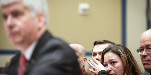 Flint Michigan resident Lee Anne Walters, second from right, reacts as Rick Snyder, governor of Michigan, left, testifies during a House Oversight and Government Reform Committee hearing in Washington, D.C., U.S., on Thursday, March 17, 2016. Democrats in Congress Thursday called on Snyder, once a rising Republican star considered as a potential vice president and now fighting to keep his job, to resign for missing the warning signs of lead contamination in Flints water supply. Photographer: Pete Marovich/Bloomberg via Getty Images 