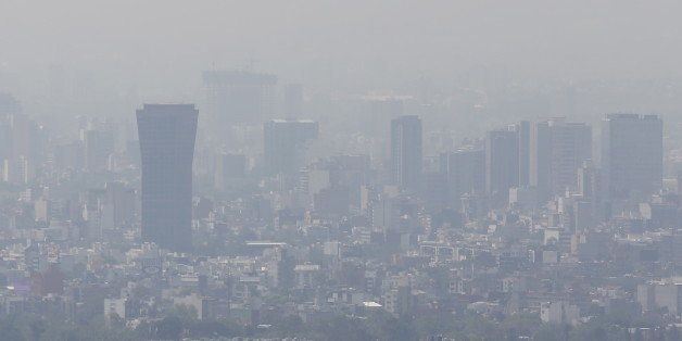 Buildings stand shrouded in smog in Mexico City, March 15, 2016. Mexico City's government ordered traffic restrictions on Tuesday and recommended people stay indoors due to serious air pollution, issuing its second-highest alert warning for ozone levels for the first time in 13 years. REUTERS/Edgard Garrido