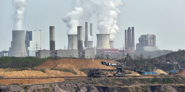 FILE - In this April 3, 2014 file photo giant machines dig for brown coal at the open-cast mining Garzweiler in front of a smoking power plant near the city of Grevenbroich in western Germany. The U.N.âs expert panel on climate change is preparing a new report this weekend outlining the cuts in greenhouse gases, mainly CO2 from the burning of fossil fuels, required in coming decades to keep global warming in check. (AP Photo/Martin Meissner, File)