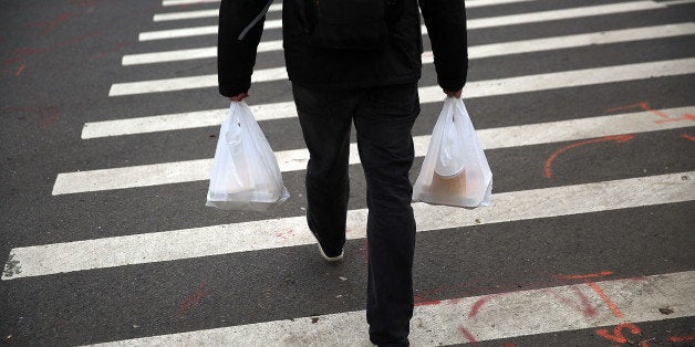 NEW YORK, NY - MAY 05: A man walks out of a store with a plastic bags on May 05, 2016 in New York City.New York's City Council is scheduled to vote Thursday on a bill that would require most stores to charge five cents per bag in an effort to cut down on plastic waste. New York's sanitation department estimates that every year 10 billion bags are thrown in the trash. (Photo by Spencer Platt/Getty Images)