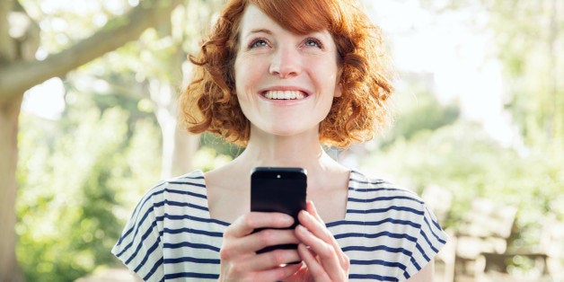 Woman using smart phone outside.