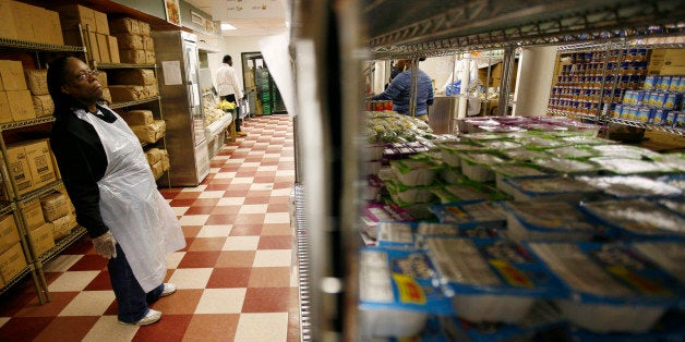 A staff member looks at groceries on shelves at the Community Kitchen food pantry in the Harlem section of New York City December 10, 2008. Operator Food Bank for New York City, which provides half of all the emergency food to the 1000 plus soup kitchens and pantries in New York City, says they have seen a large increase in those seeking food aid and services as the U.S. has experienced a deepening economic slowdown. REUTERS/Mike Segar (UNITED STATES)