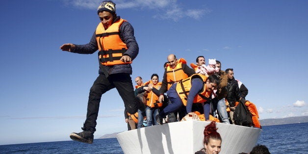 Refugees and migrants jump off a boat as they arrive on the Greek island of Lesbos, November 26, 2015. REUTERS/Giorgos Moutafis