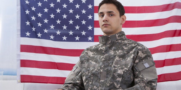 Cropped image of patriotic soldier sitting on wheel chair against American flag