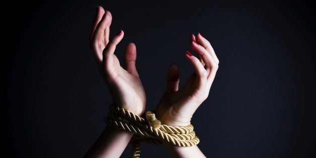 Close up of female hands tied in a rope