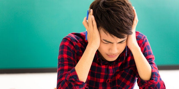 Stressed student studying for exam in classroom