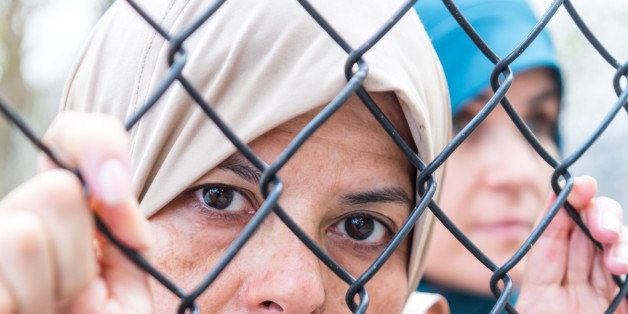 Middle eastern mature women posing looking looking through a fence very sad