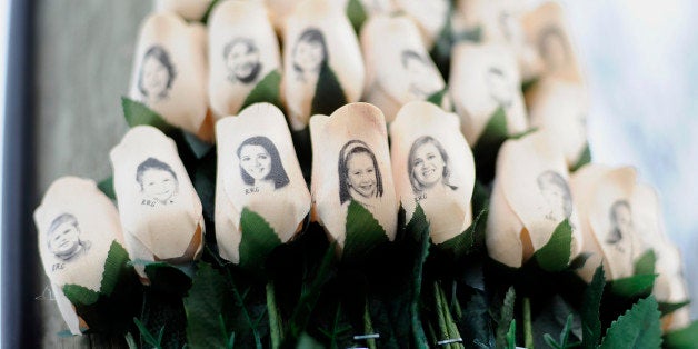 FILE - In this Jan. 14, 2013 file photo, white roses with the faces of victims of the Sandy Hook Elementary School shooting are attached to a telephone pole near the school on the one-month anniversary of the shooting that left 26 dead in Newtown, Conn. Some Newtown families have said they were given a voice late in the process of dispersing the millions of dollars in donated funds, and that the process has been bureaucratic, difficult, unpleasant, and has added to their pain. (AP Photo/Jessica Hill, File)