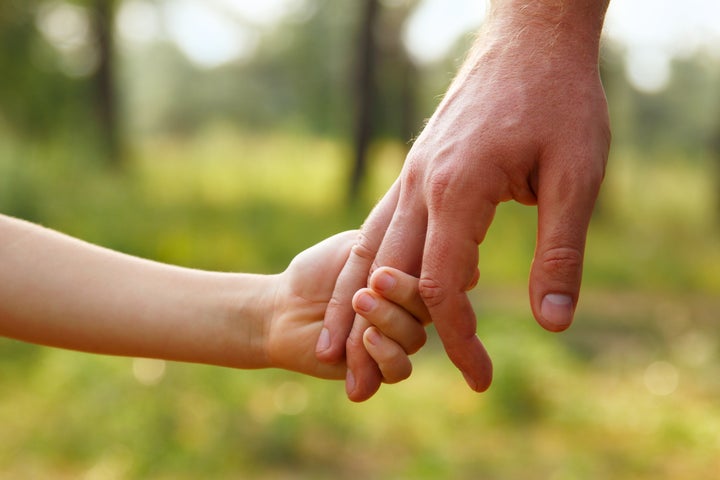 father's hand lead his child son in summer forest nature outdoor, trust family concept