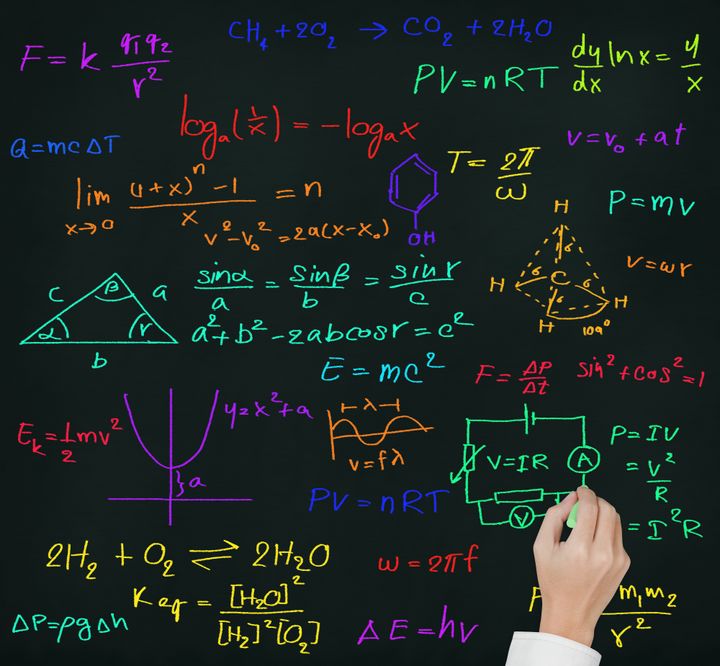 teacher hand writing high school maths and science formula on blackboard