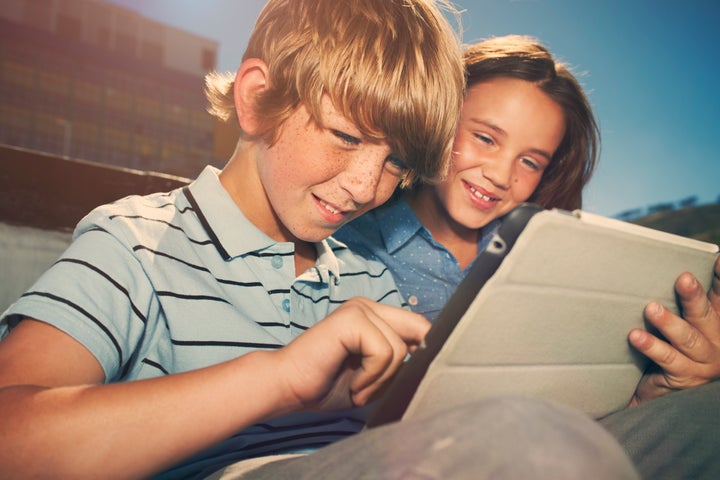 Boy and girl playing with digital tablet