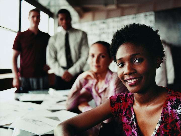 Portrait of a Fashion Designer Sitting in Front of Three of Her Colleagues at a Desk