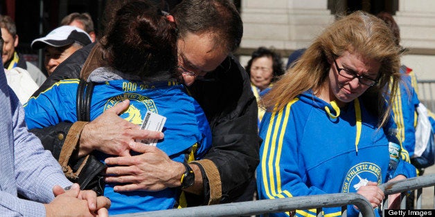 BOSTON, MA - APRIL 16: Runners waiting to pick up their belongings and medals hug the day after two bombs exploded at the finish of the Boston Marathon, on April 16, 2013 in Boston, Massachusetts. The city is cordoned off around the bomb site and filled with law enforcement officials, federal and state. Officials are calling it a terrorist attack. (Photo by Melanie Stetson Freeman/The Christian Science Monitor via Getty Images)