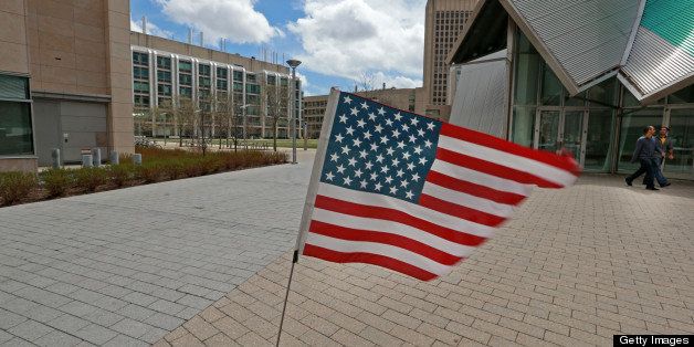 CAMBRIDGE, MA - APRIL 19: An American flag flutters in the wind at the scene of the murder of MIT police officer Sean Collier. Part of the MIT Koch Institute is at far left, the Stata Center is at right, both located in Kendall Square. There is a Lockdown-in-Place in effect as a manhunt is underway for a suspect in the terrorist bombing of the 117th Boston Marathon earlier this week. (Photo by Jim Davis/The Boston Globe via Getty Images)