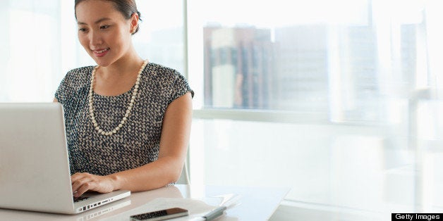 Businesswoman using laptop in office