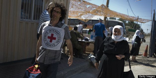 EDITOR'S NOTE ==== RESTRICTED TO EDITORIAL USE - MANDATORY CREDIT 'AFP PHOTO /ICRC/ALESSIO ROMENZI' NO MARKETING NO ADVERTISING CAMPAIGNS DISTRIBUTED AS A SERVICE TO CLIENTS ==== A picture handout the International Red Cross shows an ICRC staff helping a Druze pilgrim crossing from the Israeli-occupied Golan Heights into Syria on September 15, 2011 after over 500 Druze have been allowed to cross through the Kuneitra crossing. The International Committee of the Red Cross (ICRC), acting in its capacity as a neutral humanitarian intermediary, facilitated the crossing. The ICRC works with Israeli and Syrian officials on both sides of the UN-controlled demilitarized zone to enable residents to cross back and forth for humanitarian, educational and religious purposes. AFP PHOTO/HO/ICRC/Alessio Romenzi (Photo credit should read Alessio Romenzi/AFP/Getty Images)