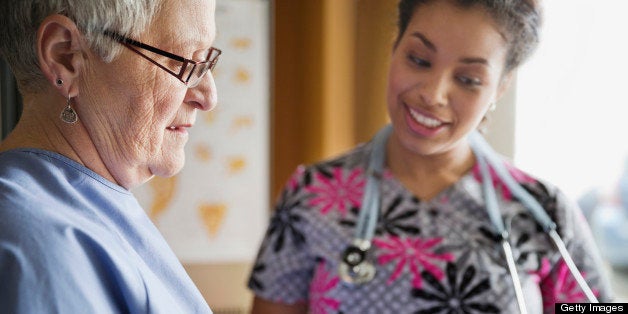 Senior woman discussing prescription medicine with nurse in clinic