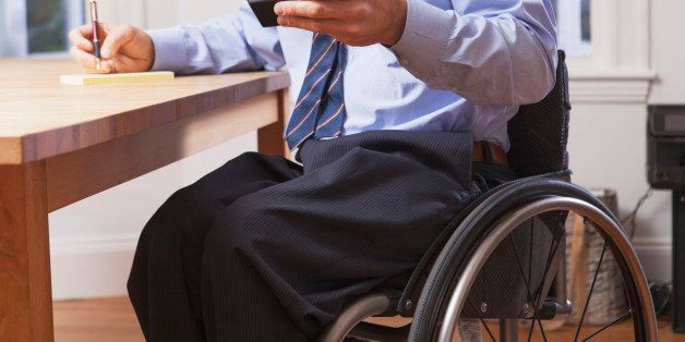 Businessman with spinal cord injury in a wheelchair using a smartphone