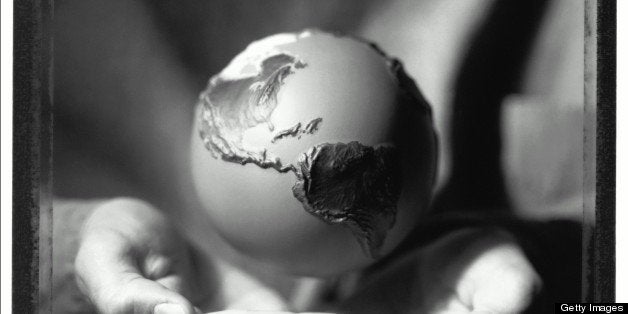 Globe hovering above cupped hands, close-up (B&W)