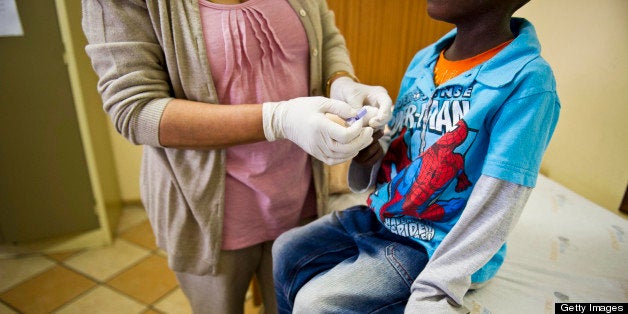 JOHANNESBURG, SOUTH AFRICA - JANUARY 27: (SOUTH AFRICA OUT) Sister Sally Naidoo administers an HIV test on a young boy at the Right To Care AIDS clinic on January 27, 2012 in Johannesburg, South Africa. The Right to Care non-governmental organisation has, with US funding from PEPFAR managed to revive their Alexandra based AIDS clinic.The clinic is now providing quality medical treatment to more than 8000 patients. (Photo by Foto24/Gallo Images/Getty Images)