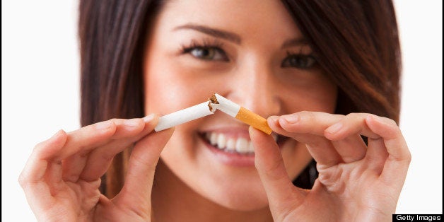 Young woman breaking cigarette