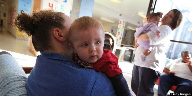 DECATUR, IL - FEBRUARY 18: Lydia Phillips (L) holds eight-month-old Skyler while Brandi Ceci plays with her three-month-old daughter Alexis in the common area of their ward at Decatur Correctional Center February 18, 2011 in Decatur, Illinois. Both children were born while their mothers were serving time at the prison. They now stay at the prison together, part of the Moms with Babies program at the minimum security facility. The program allows incarcerated women to keep their newborn babies with them for up to two years while serving their sentence. The program boasts a zero percent recidivism rate compared to the statewide rate of 51.3 percent. (Photo by Scott Olson/Getty Images)