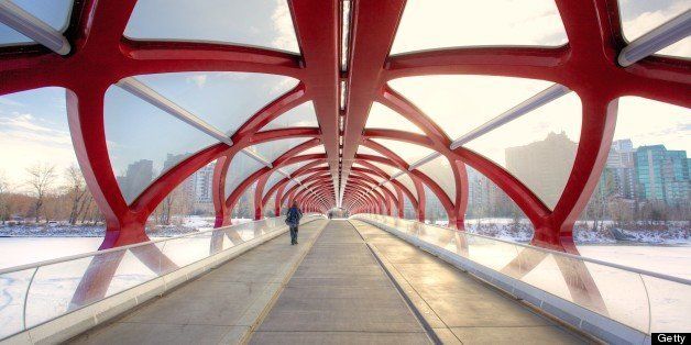 Calgary's Peace Bridge, designed by Calatrava spans the Bow River in Calgary. A unique interlacns crossing. Looking towaing design it is eye catching and beautiful. Here we see it on a bright sunny day in January with pedestriards the downtown core.