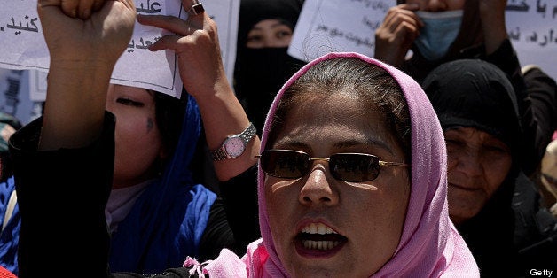 Afghan university students and independent civil society activists take part in a demonstration in support of passing the Elimination of Violence against Women law in front of Parliament in Kabul on May 27, 2013. The Afghan parliament on May 18 cut short a debate on a bill to protect women from violence after complaints from some traditionalist MPs that it was against Islamic teaching. The Elimination of Violence against Women (EVAW) law, which was passed by a presidential decree in 2009, is seen as a benchmark piece of legislation marking progress since the fall of the Taliban regime nearly 12 years ago. AFP PHOTO/ SHAH Marai (Photo credit should read SHAH MARAI/AFP/Getty Images)