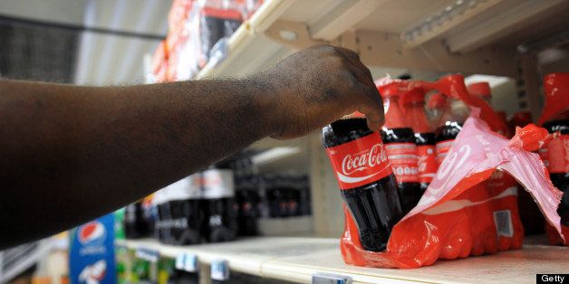A man picks up a Coca Cola bottle in a supermarket of Fort-de-France, on March 30, 2013 in the French caribean island of La Martinique. The French national assembly on March 27, 2013 ruled to align the additional sugar rates of the products sale in the overseas territories with the mainland's rates. AFP PHOTO JEAN-MICHEL ANDRE (Photo credit should read JEAN-MICHEL ANDRE/AFP/Getty Images)