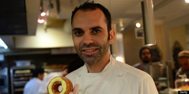 TO GO WITH AFP STORY French pastry chef Dominique Ansel poses with a cronut, a croissant-doughnut hybrid, which he created, at his bakery shop in New York, June 14, 2013. Customers line up for hours before Ansel's shop opens in the morning to have a chance to buy two cronuts per person out of the 200 cronuts Ansel produces daily. The part flaky croissant, part cream-filled doughnut, the cronut, was introduced in mid-May and is retailing at $5 USD a piece. AFP PHOTO/Emmanuel Dunand (Photo credit should read EMMANUEL DUNAND/AFP/Getty Images)