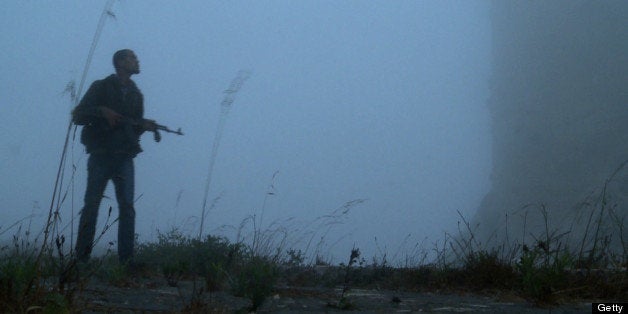 An image grab taken from AFP TV shows a Syrian rebel taking position at the Crac des Chevaliers near the village of Azzara on the outskirts of the flashpoint city of Homs on June 28, 2012. Protected by the night, Syrian rebels climb on board motorcycles, lights off, on their way to the Crac des Chevaliers, a crusader castle which they are fiercely defending against government forces who continue to attack the area with tanks and artillery. AFP PHOTO/DJILALI BELAID (Photo credit should read DJILALI BELAID/AFP/Getty Images)