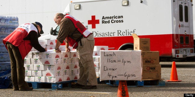 Volunteers with the American Red Cross review their notes as they distribute relief supplies to Hurricane Sandy victims November 5, 2012, in Ocean County, New Jersey. The Red Cross vans shuttle in food on 'search and feed' missions to victims in devastated costal areas. AFP PHOTO/Paul J. Richards (Photo credit should read PAUL J. RICHARDS/AFP/Getty Images)