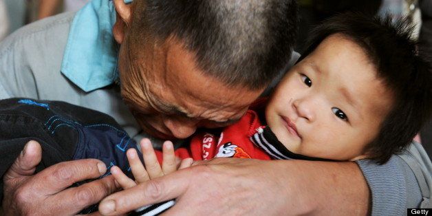 Wang Bangyin breaks down as he hugs his rescued son at Guiyang Welfare Center for Children in Guiyang, southwest China's Guizhou province on October 29, 2009, as Wang's son was among the 60 children police rescued from human traffickers. Police in China have set up a website aimed at locating the families of up to 60 children recovered during a six-month crackdown on human trafficking, state press reported. CHINA OUT AFP PHOTO (Photo credit should read STR/AFP/Getty Images)