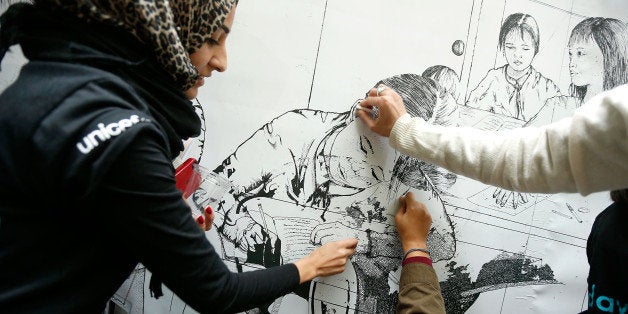 NEW YORK, NY - OCTOBER 11: Attendees of the Innovate 2 Educate program, which marks International Day of the Girl, work on a giant erasable fresco staged by Plan International and UNICEF at UNICEF House on October 11, 2013 in New York City. The billboard portrays an image of girls working in a typical sweatshop, which when erased revealed girls in their rightful place, in the classroom. (Photo by J. Countess/Getty Images)