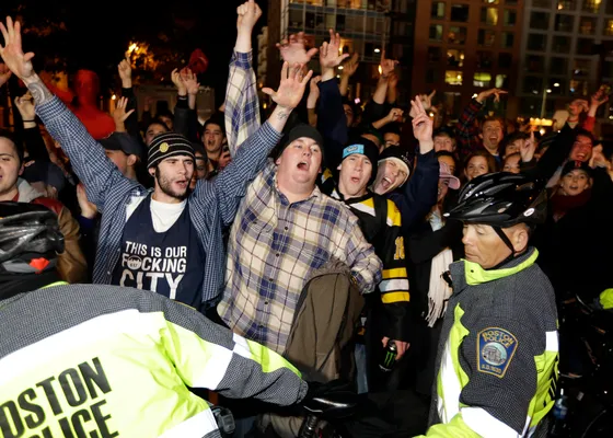 An unidentified man blocks police in riot gear outside Fenway Park in  Boston after the Boston Red Sox swept the St. Louis Cardinals to win the  World Series Wednesday, Oct. 27, 2004. (