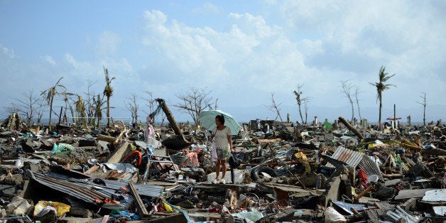 A surivor walks among the debris of houses destroyed by Super Typhoon Haiyan in Tacloban in the eastern Philippine island of Leyte on November 11, 2013. The United States, Australia and the United Nations mobilised emergency aid to the Philippines as the scale of the devastation unleashed by Super Typhoon Haiyan emerged on November 11. AFP PHOTO / NOEL CELIS (Photo credit should read NOEL CELIS/AFP/Getty Images)