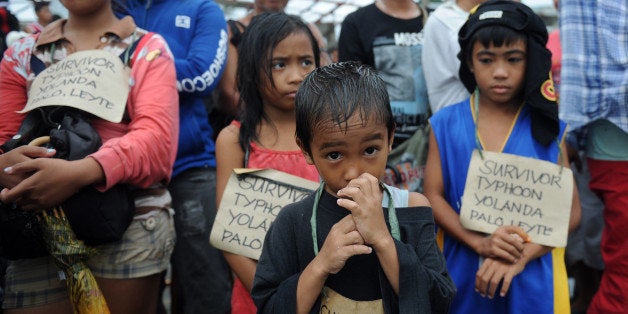 Survivors of the super Typhoon Haiyan, wait for a C-130 military plane at Tacloban airport, Leyte province, central Philippin