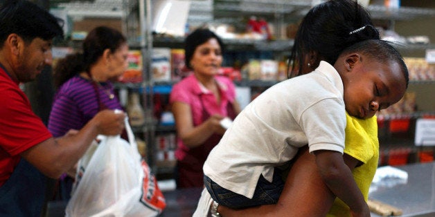 NEW YORK, NY - JULY 24: Jaden Painegua (2) rests on his mother's shoulder at the West Side Campaign Against Hunger food bank on July 24, 2013 in New York City. The food bank assists thousands of qualifying New York residents in providing a monthly allotment of food. In an anticipated speech today in Illinois, President Obama tried to re-focus the nations attention back onto the economy and the growing inequality between the rich and the rest of America. As of May 2013 the unemployment rate in America was stuck at 7.6% with many more Americans having given up on looking for work. (Photo by Spencer Platt/Getty Images)