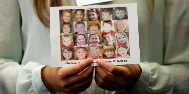 WASHINGTON, DC - SEPTEMBER 18: Kyra Murray holds a photo with victims of the shooting at Sandy Hook Elementary School during