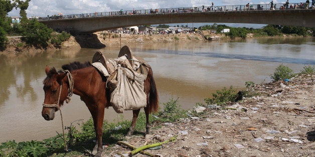 ST MARC, HAITI - OCTOBER 27: People walk over a bridge crossing the Artibonite River, believed to be the polluted source of the Cholera epidemic, October 27, 2010 in St. Marc, Haiti. Haiti, one of the poorest nations in the Western Hemisphere, has been further unsettled by an outbreak of cholera which has so far killed nearly 300 people as of Tuesday. The epidemic has affected the central Artibonite and Central Plateau regions with 3,612 cases so far on record. While authorities believe the outbreak is contained, they believe it has not yet peaked. There is also fear that the deadly diarrheal disease could migrate to the sprawling camps for the hundreds of thousands of Haitians displaced by the earthquake. (Photo by Spencer Platt/Getty Images)