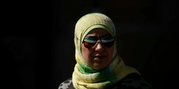 The Syrian National Coalition flag is reflected in a woman's sunglasses during a rally against Syrian President Bashar al-Ass