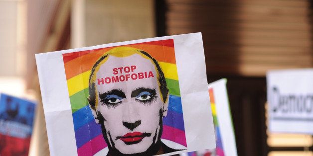 MADRID, SPAIN - AUGUST 23: A protestor holds up an image representing Russian President Vladimir Putin wearing lipstick during a protest against Russian anti-gay laws opposite the Russian embassy on August 23, 2013 in Madrid, Spain. Gay protestors are protesting Russia's new anti-gay laws and demanding the cancellation of the upcoming 2014 Winter Olympics scheduled to be held in Sochi, Russia. (Photo by Denis Doyle/Getty Images)