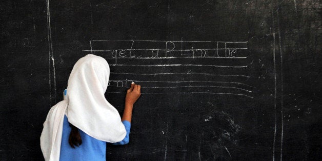 A Pakistani female student writes a sentence on a black board at a government school in Peshawar on October 25, 2012. AFP PHOTO/A. MAJEED (Photo credit should read A. MAJEED/AFP/Getty Images)