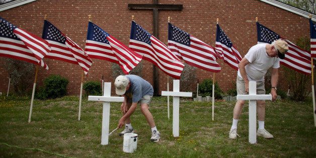KILLEEN, TX - APRIL 03: Bob Butler (L) and Bob Gordon paint crosses they placed in front of 16 American flags as they build a memorial in front of Central Christian Disciples of Christ church for the victims of yesterdays shooting at Fort Hood on April 3, 2014 in Killeen, Texas. Iraq war veteran, Ivan Lopez, is reported to be the shooter that claimed three lives and wounded 16 more before taking his own life at Fort Hood. (Photo by Joe Raedle/Getty Images)