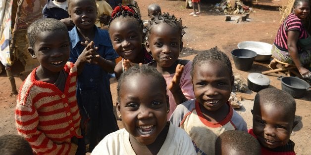 Children pose for the photographer as they live with other refugees in the aero-club near Mpoko Bangui airport where 100.000 people are refuged on January 8, 2014. Centrafican President Michel Djotodia and Prime miniter Nicolas Tiangaye are on their way to N'Djamena to attend a summit on the Centrafrica unrest on January 9, 2014. AFP PHOTO ERIC FEFERBERG (Photo credit should read ERIC FEFERBERG/AFP/Getty Images)