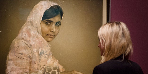 A gallery worker poses with a painted portrait of Malala Yousafzai, the teenage Pakistani advocate for girls education who was shot in the head by the Taliban in 2012, by Jonathan Yeo at the National Portrait Gallery in central London on September 10, 2013. the portrait will be unveiled to the public alongside a selection of other works by the artist as part of the 'Jonathan Yeo Portraits' exhibition, running from September 11, 2013 to January 5, 2014. AFP PHOTO / LEON NEAL -- RESTRICTED TO EDITORIAL USE, MANDATORY MENTION OF THE ARTIST UPON PUBLICATION, TO ILLUSTRATE THE EVENT AS SPECIFIED IN THE CAPTION (Photo credit should read LEON NEAL/AFP/Getty Images)